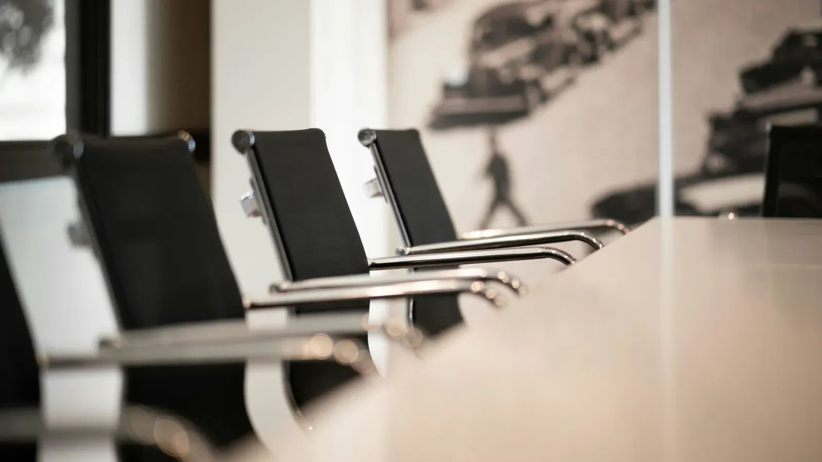 Leere Bürostühle in einer Reihe an einem Konferenztisch
