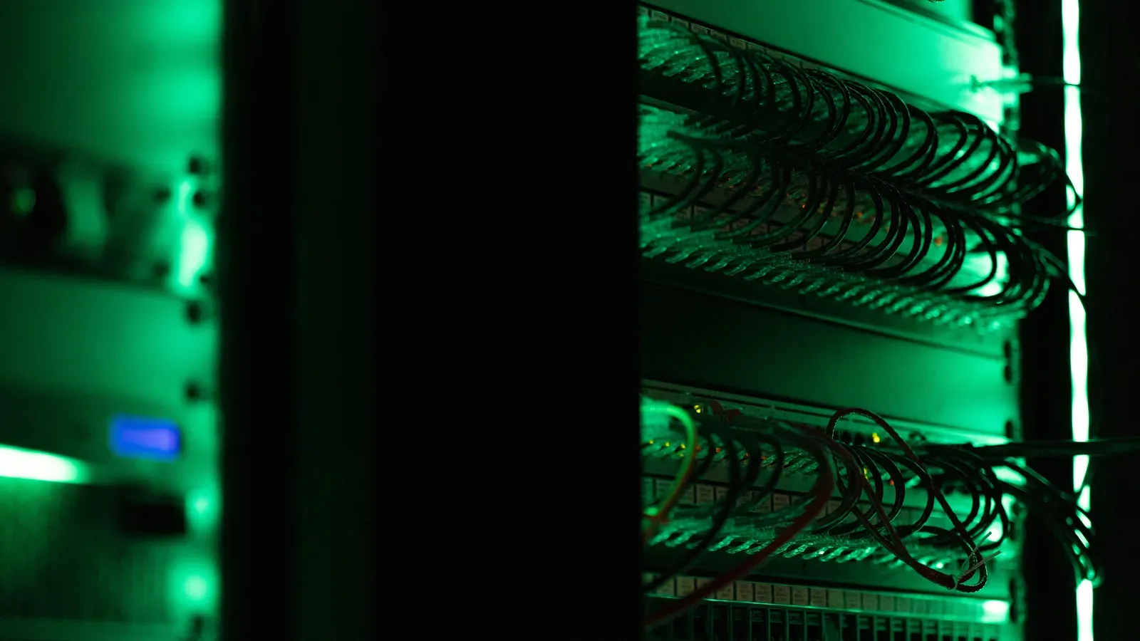 Serverschrank mit Netzwerktechnik in einem abgedunkelten Raum