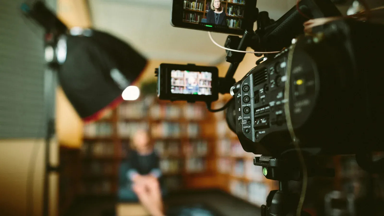 Videokamera auf einem Stativ vor einer Interviewsituation im Studio