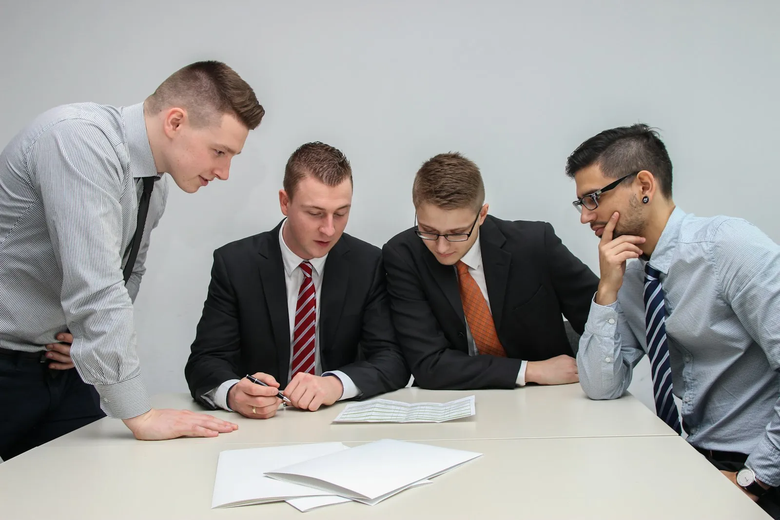 Vier Personen besprechen gemeinsam Unterlagen an einem Tisch